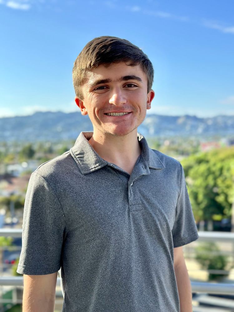 Ben Knobloch in front of a sky-blue background.